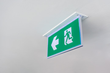 Green emergency exit sign. Direction to the escape way.