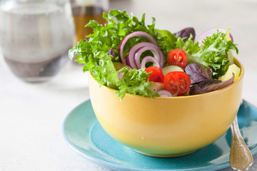 Fresh salad with mixed greens and cherry tomato in bowl