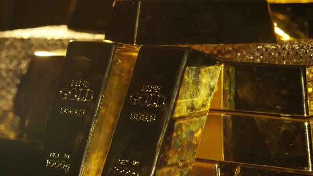  Close up gold bars on shimmering rotating stand, wealth & luxury concept.