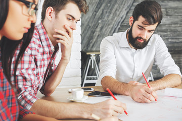 European people doing paperwork and using devices