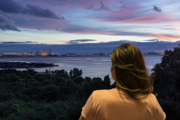 Asian woman looking at Laem Chabang Port view at night