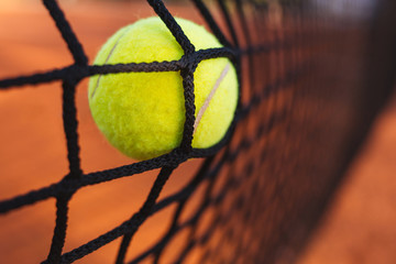 Tennis ball in tennis net