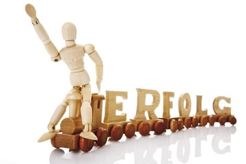 Erfolg, German for success, written with wooden letters on a wooden train