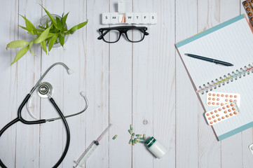 Doctor table with medical items, stethoscope and pills