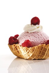 Raspberry ice cream, whipped cream and raspberries in a wafer bowl