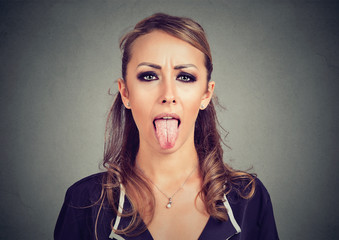 Closeup portrait of a woman sticking her tongue out © pathdoc