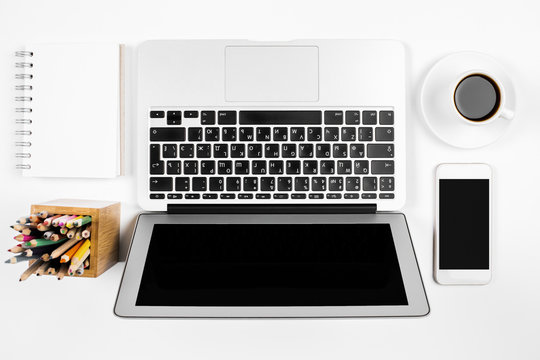 White desk with laptop and smartphone