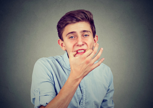 Teenager man trying to whistle isolated on gray wall background