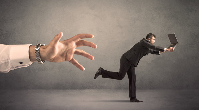 Businessman running from hand