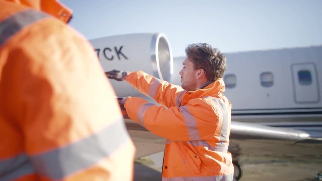  Aircraft engineers with blueprint checking over plane on the runway