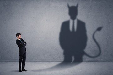 Obraz premium Business man looking at his own devil demon shadow concept