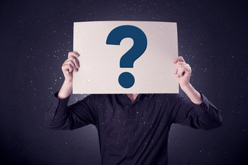 Businessman holding paper with question marks
