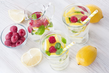 Fresh lemon and raspberry water drink / Fresh lemon and raspberry cold water drink lemonade with mint in two glass