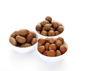Assorted nuts in ceramic bowls, macadamia nuts, peanuts, hazelnuts