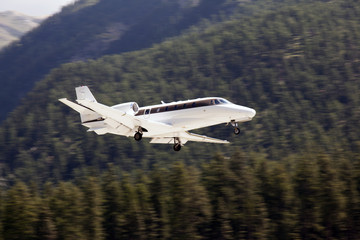 Fototapeta na wymiar An executive jet landing in the airport of St Moritz