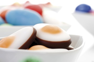 Variety of candy easter eggs and sweets in porcelain bowls