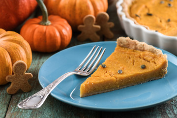 Healthy dessert for Thanksgiving. Pumpkin open pie with pumpkin seeds served with small decorative pumpkins and wholegrain gingerman cookies
