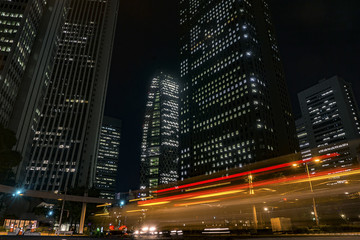 Fototapeta na wymiar The Current of Cars With Tall Buildings In the Night of Shinjuku: The Night Scene of Tokyo