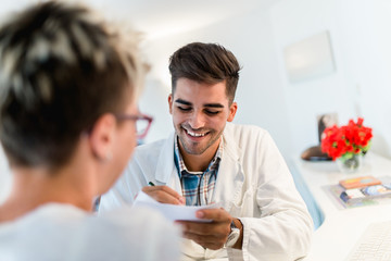 Male optometrist checking patient's vision at eye clinic. Medical examination.
