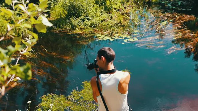 Cameraman shoots a natural river landscape on a video camera