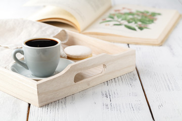 Morning breakfast, mug with coffee,  book on a wooden tray