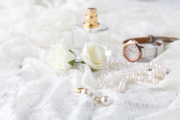 women's perfume in beautiful bottle, light background with accessories for the care and beauty