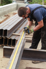 A man marks a metal product before cutting