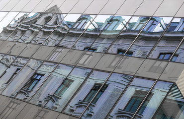 Abstrakte Fassade eines modernen Bürogebäudes,altes Wohngebäude gespiegelt, Wien,Österreich