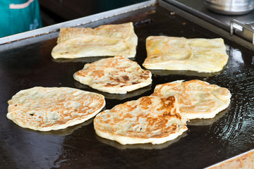 Making of Indian flat bread, roti canai