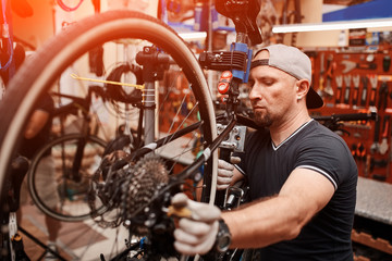 Mechanic repairing bicycle in his workshop