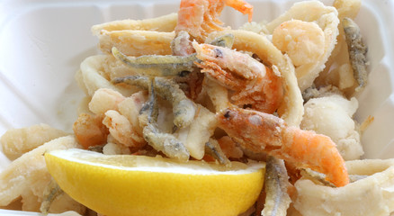 background of many fried fish with shrimp in a pan in the street