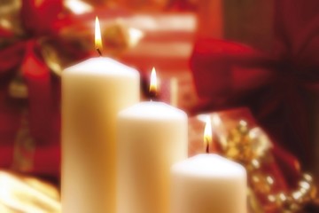 Three white burning candles, lit candles