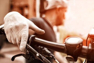 Hands in gloves on bicycle's handlebars