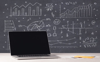 Financial business charts and office laptop