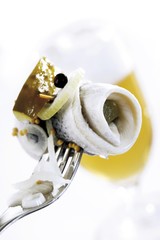Rollmops with pickles and onions on a fork