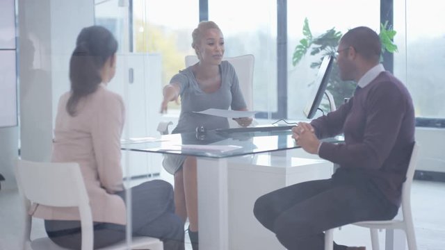  Business team including pregnant woman discussing paperwork in a meeting
