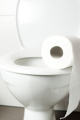 white toilet bowl and toilet paper