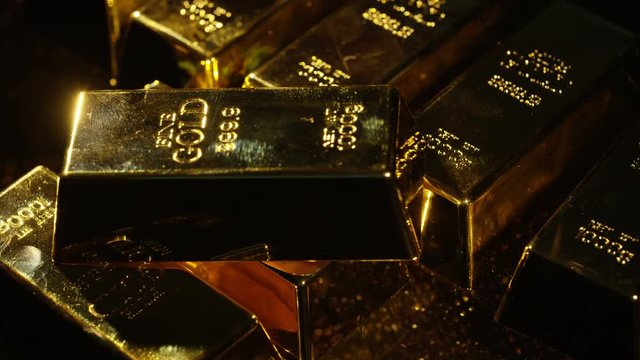  Close up gold bars on shimmering rotating stand, wealth & luxury concept.