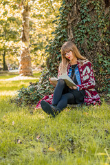 blonde enjoying the book in the park