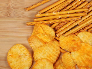 salty cracker pretzel sticks and potato chips background and texture 