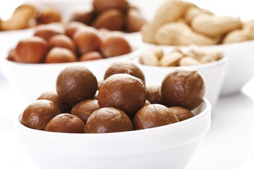 Assorted nuts in ceramic bowls, macadamia nuts, walnuts, peanuts, hazelnuts, almonds, pecans, pistachios