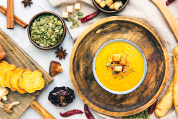 Fototapeta na wymiar Bowl with sweet potato soup and spices. Flat lay styling