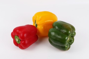 drei verschieden farbene Paprikas liegen auf dem Tisch