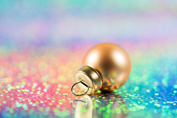 christmas holiday greeting card. xmas golden bauble on rainbow color background with copy space