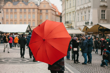 A guide with a traditional red umbrella on the Old Town Square in Prague invites tourists to visit the sights. Tourism in Christmas. Czech Republic. Europe.