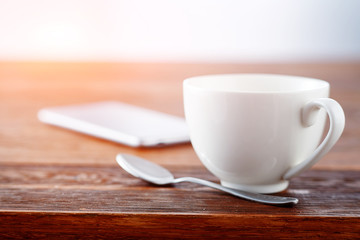 Laptop and cup of tea on rustic wooden table.