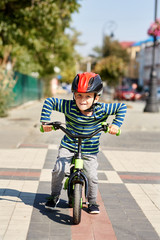 Boy in helmet standing with bike at autumn park