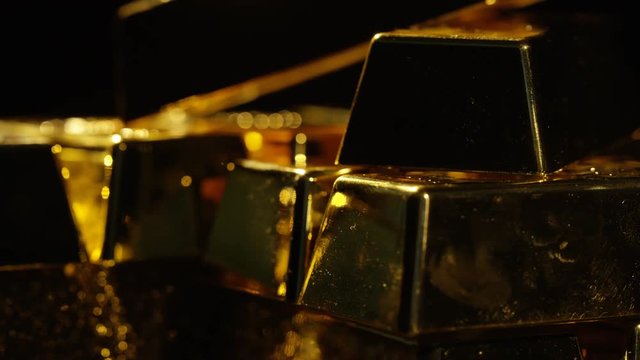  Close up gold bars on shimmering rotating stand, wealth & luxury concept.