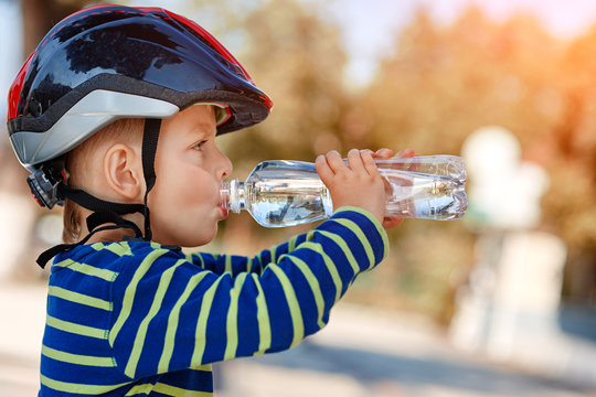 Little Boy Drinking Water By The Bike