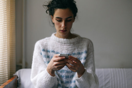 Young Brunette Woman Using Her Mobile Phone Indoor